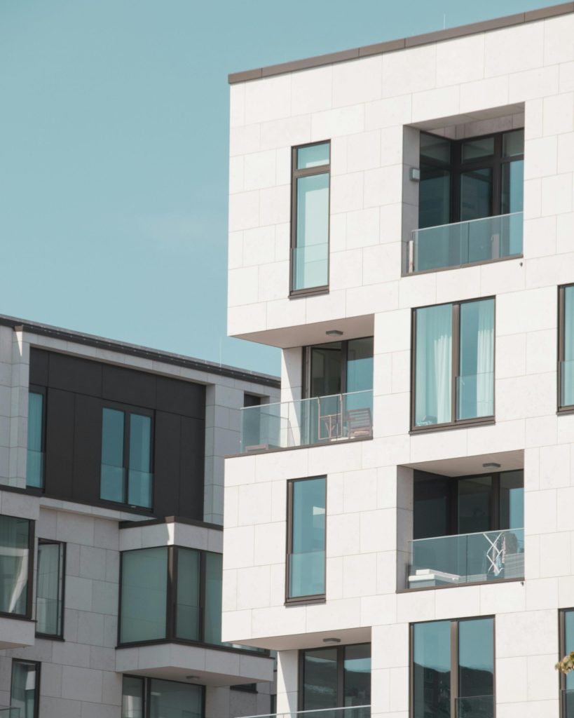 Moderne Wohngebäude in Berlin mit eleganten weißen Fassaden und Glasbalkonen.